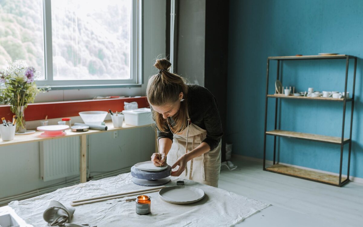 Artesã trabalhando no ateliê com luz natural
